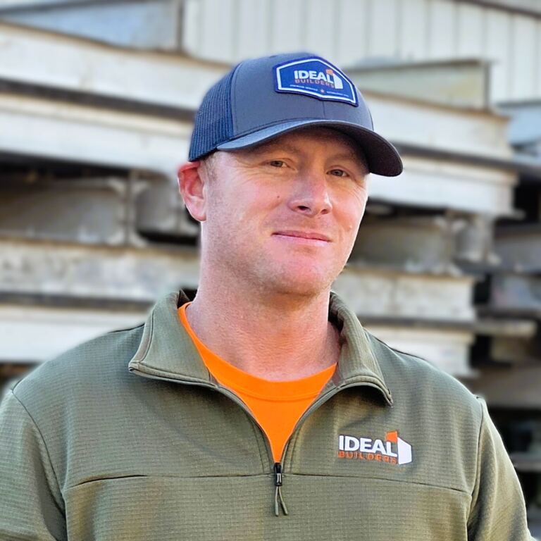 Man in a gray "Ideal Builders" hat and green jacket.